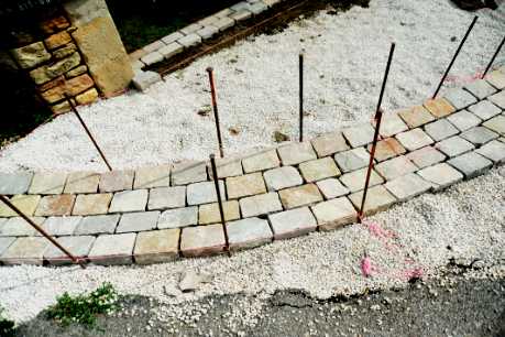 Pose de pavés en grès en forme arrondi sur chantier
