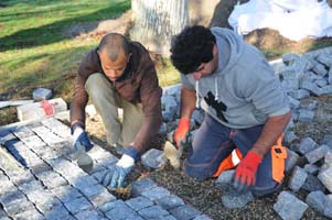 Posuers de pavés sur une allée, pavés granit gris